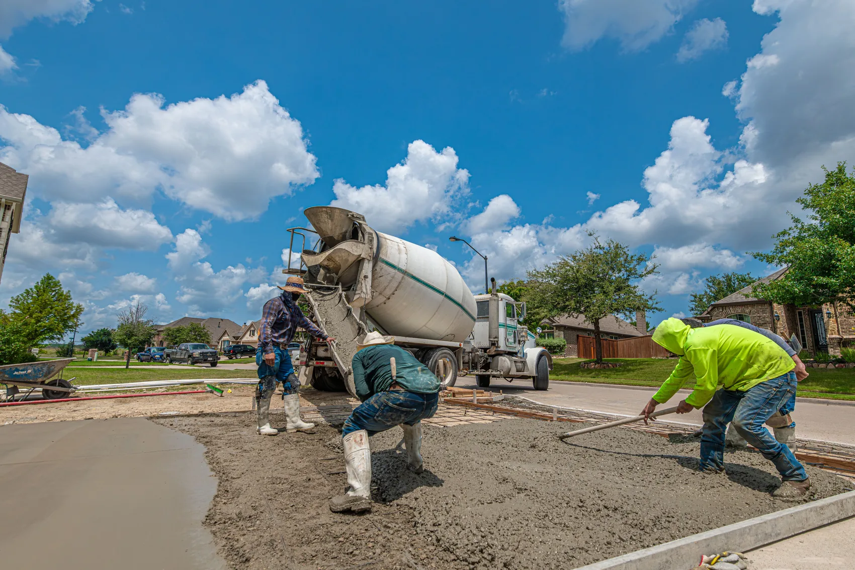 An Ironleaf crew screeding a freshly poured concrete driveway