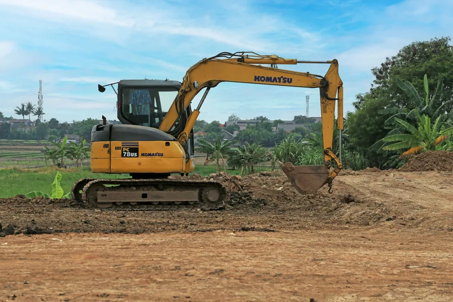 An excavator working an open site on a clear day